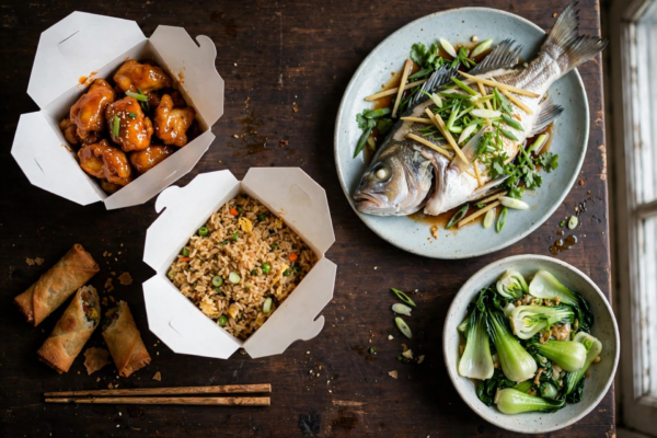 Side-by-side comparison of American Chinese takeout and traditional Chinese dishes on a wooden table